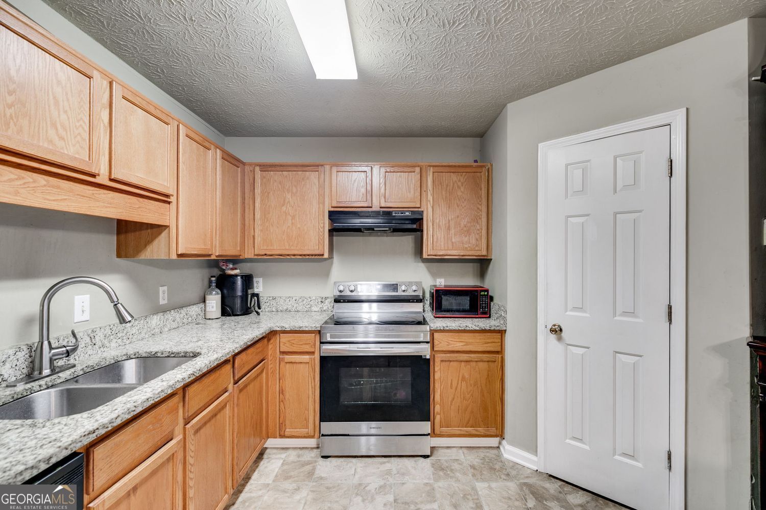 674 Fairview Drive Dallas, GA 30157 - Photo 9 of 24 a kitchen with granite countertop a stove top oven sink and cabinets