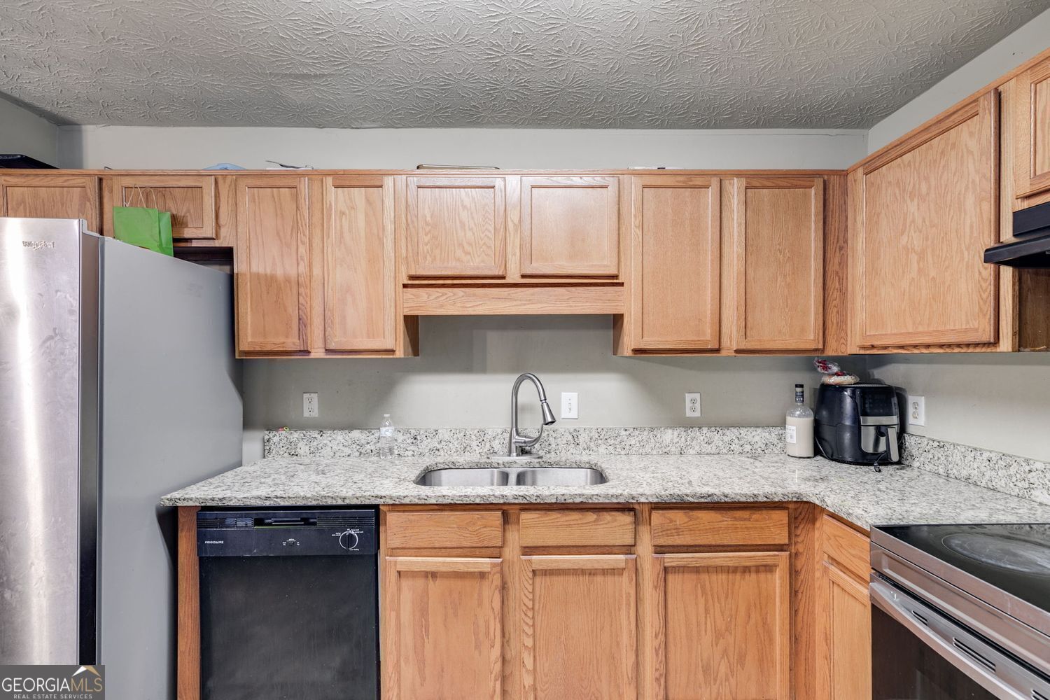 674 Fairview Drive Dallas, GA 30157 - Photo 10 of 24 a kitchen with granite countertop a sink stove and refrigerator