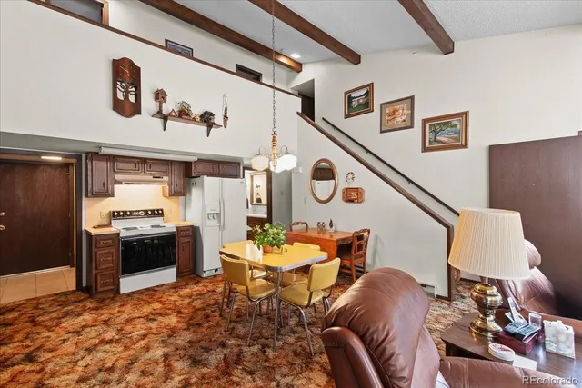 a living room with furniture and kitchen view