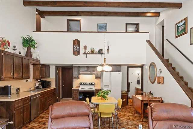 a living room with furniture kitchen view and a window