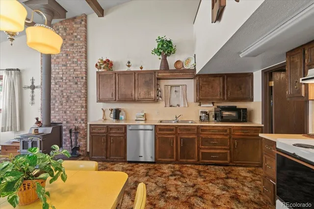 a kitchen with stainless steel appliances granite countertop a sink a stove and a refrigerator