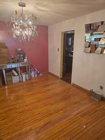 a bedroom with wooden floor and chandelier
