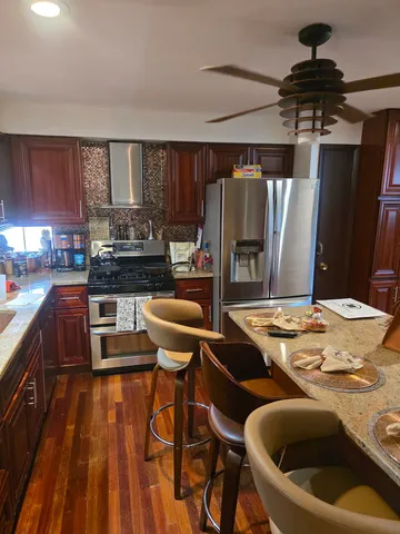 a kitchen with stainless steel appliances granite countertop a sink a stove and refrigerator