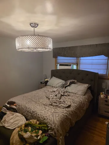 a bed sitting in a bedroom next to a lamp