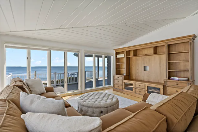 a living room with furniture two windows and a flat screen tv
