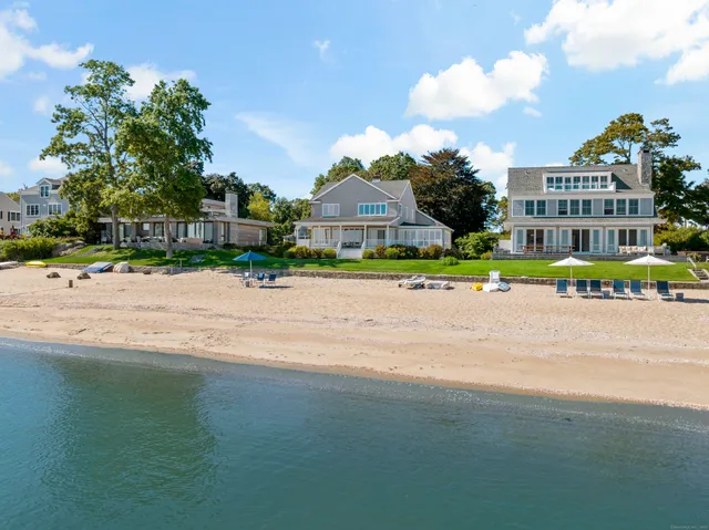 a front view of a house with a yard and trees