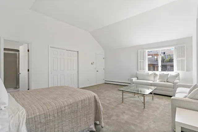 a spacious bedroom with a bed and a couch