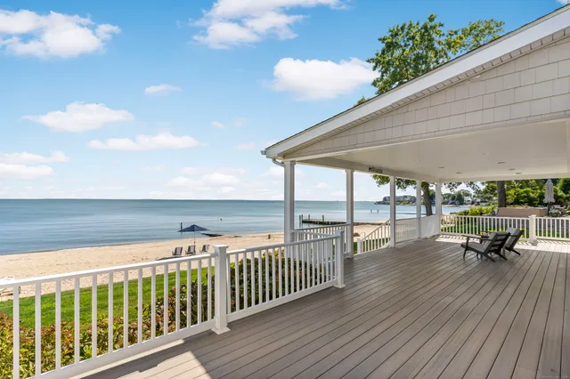 a roof deck with table and chairs and wooden floor