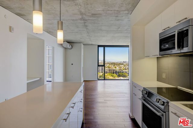 a kitchen with stainless steel appliances a stove a refrigerator and a microwave