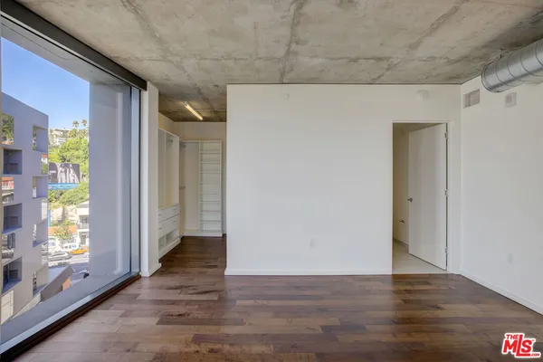 a view of a hallway with wooden floor and windows