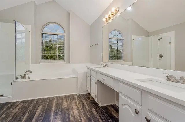 a spacious bathroom with a bathtub a sink and a large mirror