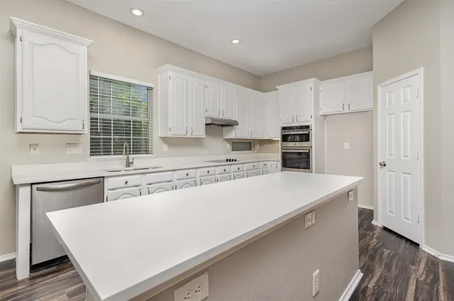 a kitchen with kitchen island a stove a sink and a refrigerator