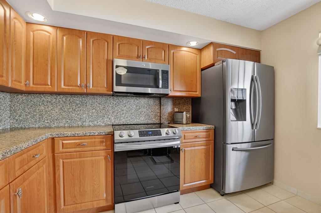 7873 La Mirada Drive, Unit 7873 Boca Raton, FL 33433 - Photo 6 of 40 a kitchen with stainless steel appliances granite countertop a refrigerator stove a sink and dishwasher