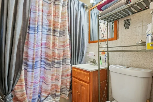 a bathroom with a granite countertop sink and a toilet