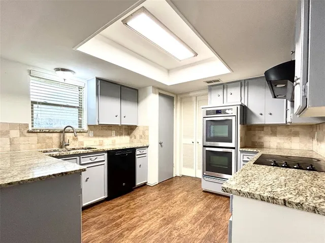 a kitchen with stainless steel appliances granite countertop a sink stove and refrigerator