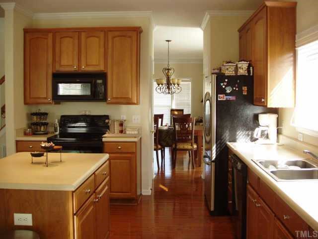 10632 Friendly Neighbor Lane Raleigh, NC 27614 - Photo 6 of 12 Kitchen with an island, a lot of cabinet space, pull out shelves interior of the cabinet and a desk to sit at.