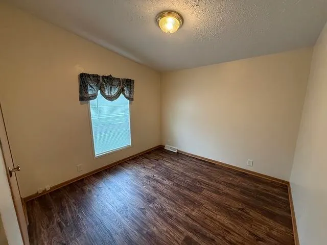 a view of an empty room and wooden floor