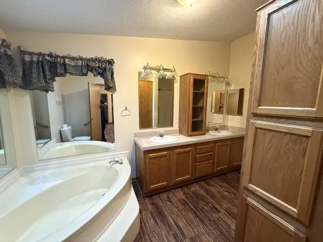 a large bathroom with a tub sink and mirror