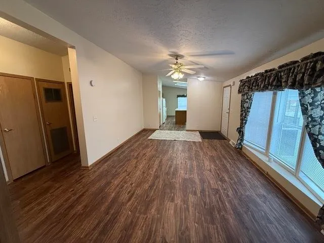 a view of a livingroom with wooden floor and staircase