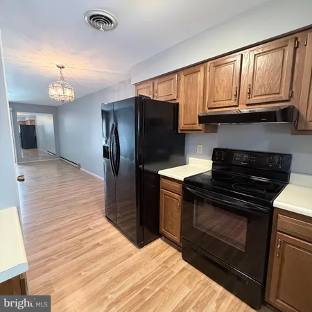 a kitchen with granite countertop wooden cabinets and stainless steel appliances