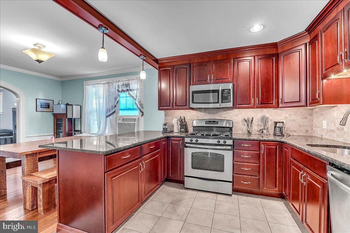 247 Sagamore Road Havertown, PA 19083 - Photo 13 of 41 a kitchen with stainless steel appliances granite countertop wooden cabinets a sink and a stove