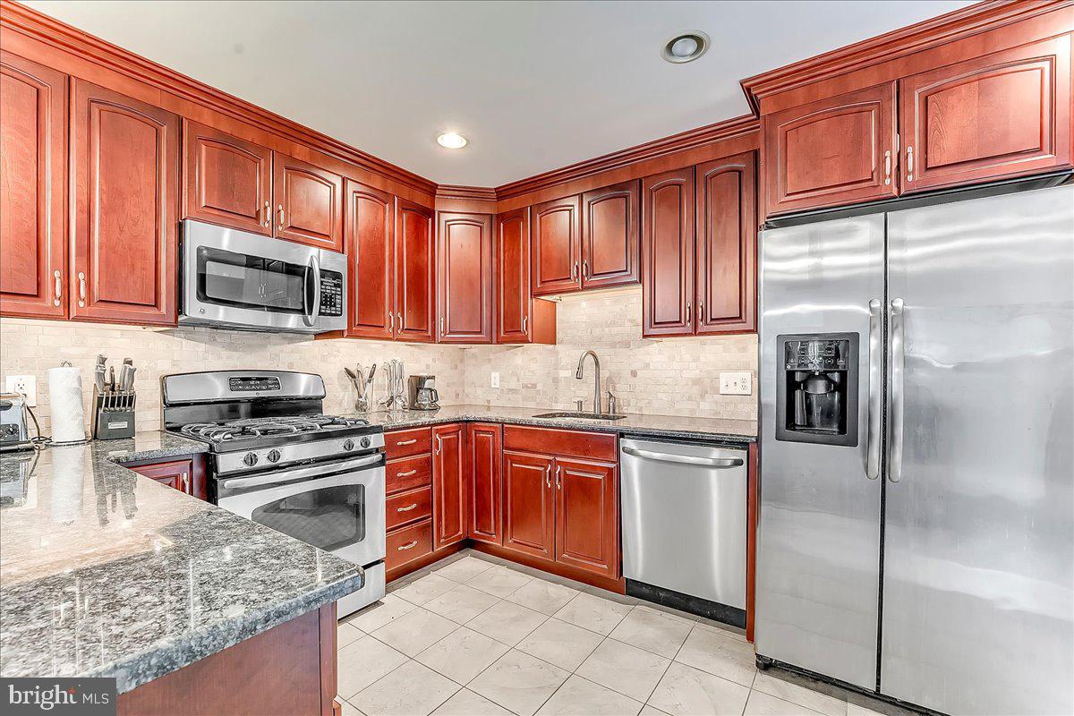247 Sagamore Road Havertown, PA 19083 - Photo 14 of 41 a kitchen with stainless steel appliances granite countertop a stove top oven a refrigerator and a sink