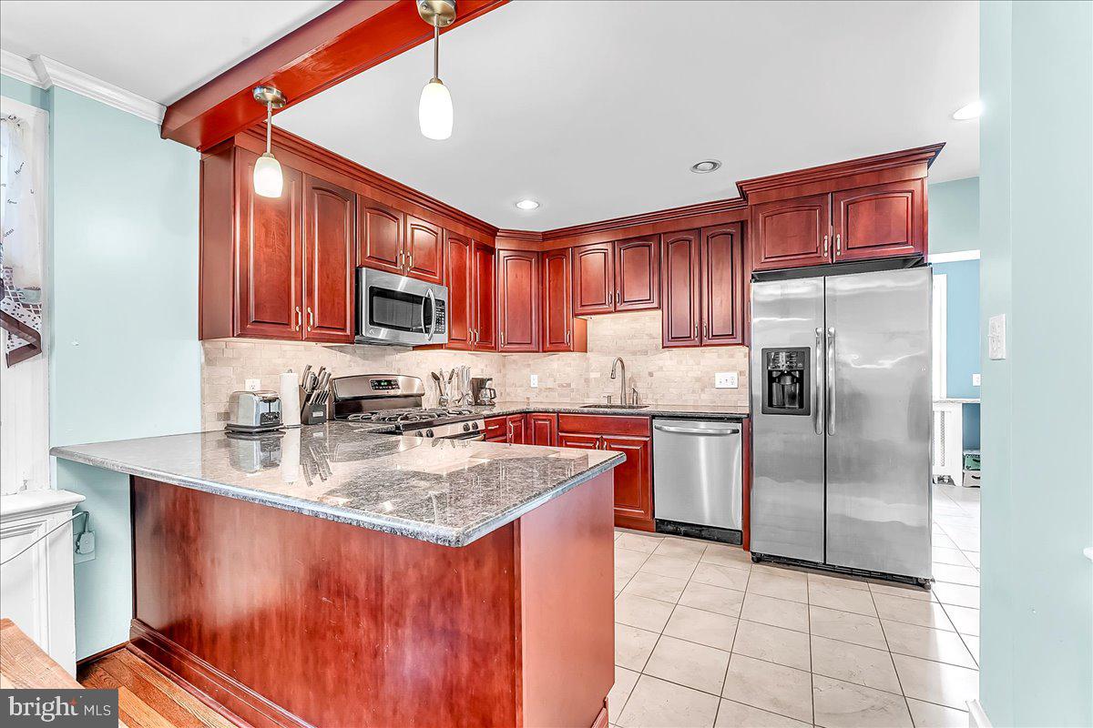 247 Sagamore Road Havertown, PA 19083 - Photo 15 of 41 a kitchen with stainless steel appliances granite countertop a sink stove refrigerator and cabinets