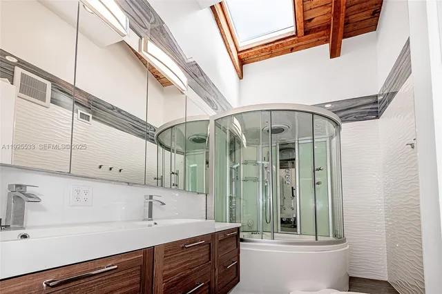 a bathroom with a sink a mirror and a shower