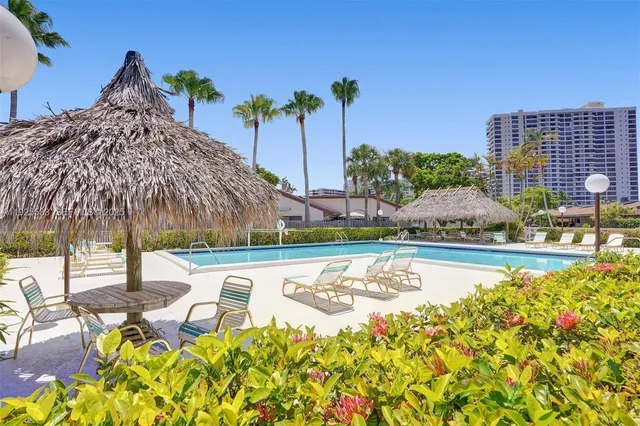 a view of a swimming pool with a patio and plants
