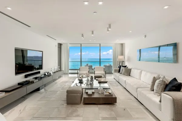 a living room with furniture a flat screen tv and a large window