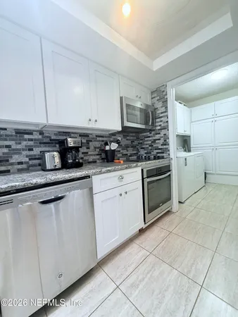 a kitchen with stainless steel appliances granite countertop a sink and cabinets