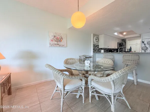 a dining room with furniture and a kitchen view