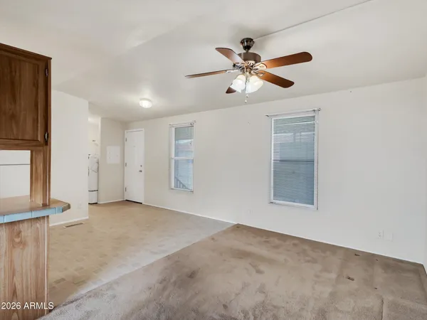 an empty room with windows and fan