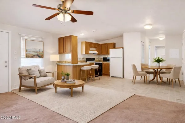 a living room with stainless steel appliances furniture a dining table and a chandelier