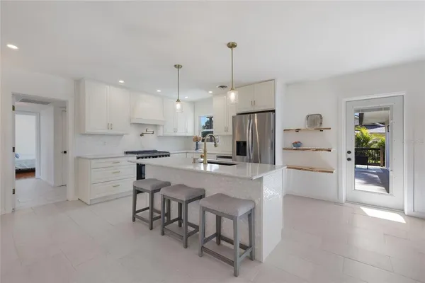 a kitchen with white cabinets and appliances