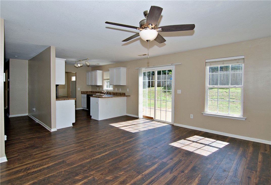 305 North Chestnut Street Seneca, SC 29678 - Photo 19 of 44 Rich wood flooring connects an open kitchen with ample living space, illuminated by natural light.