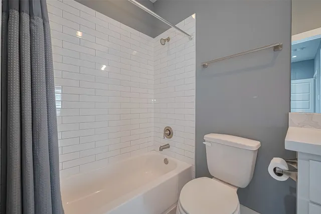 a white toilet sitting next to a bath tub