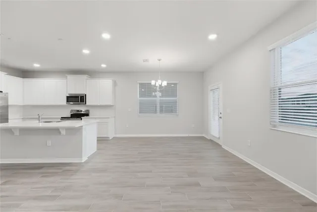 a kitchen with granite countertop a stove top oven and white cabinets