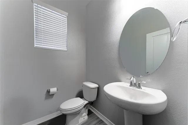 a bathroom with a sink toilet and a mirror