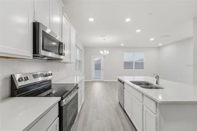 a kitchen that has a sink a stove and a microwave