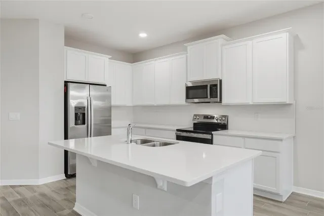a kitchen with stainless steel appliances a stove microwave and sink