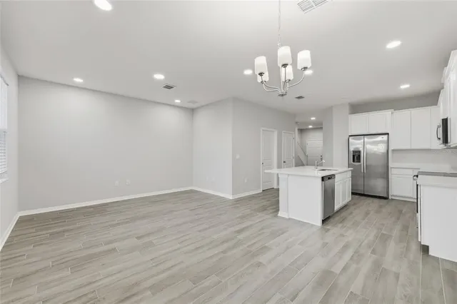 a view of a kitchen with electric appliances a refrigerator and a sink
