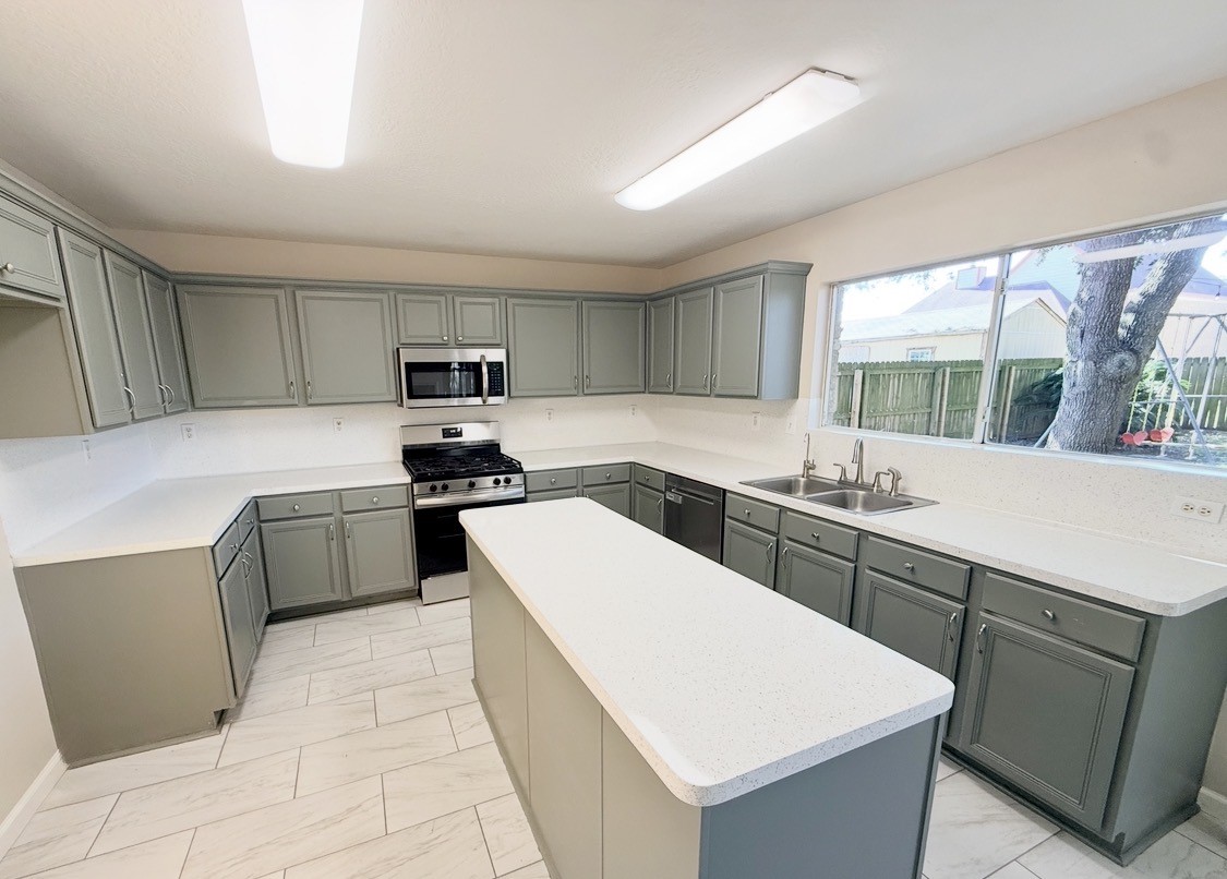 245 North Ranch House Road Angleton, TX 77515 - Photo 3 of 19 This bright, contemporary kitchen features sleek countertops, ample cabinetry, and a welcoming central island perfect for entertaining or family gatherings.