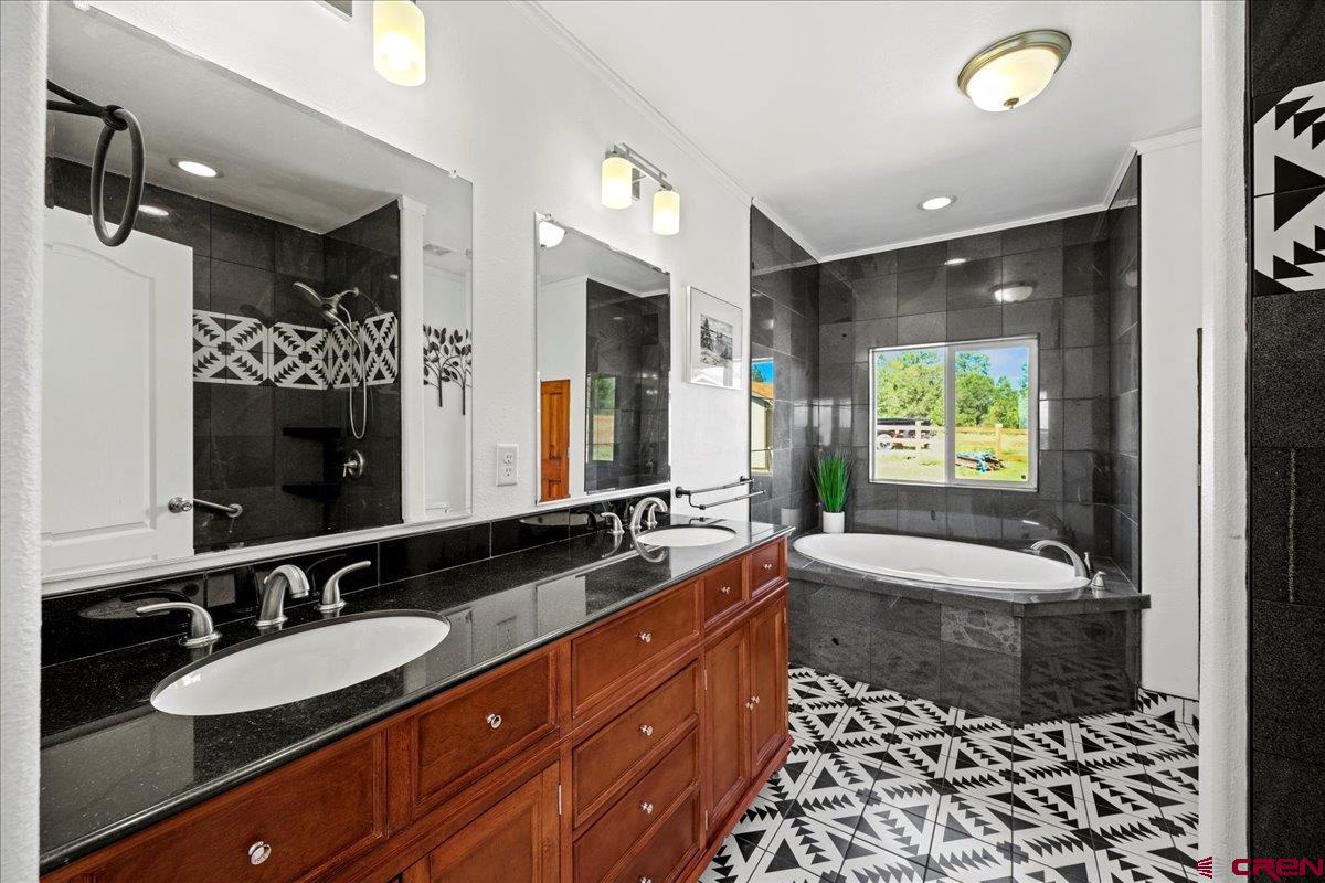 234 Thistle Drive Montrose, CO 81403 - Photo 25 of 39 a spacious bathroom with a bathtub sink and mirror