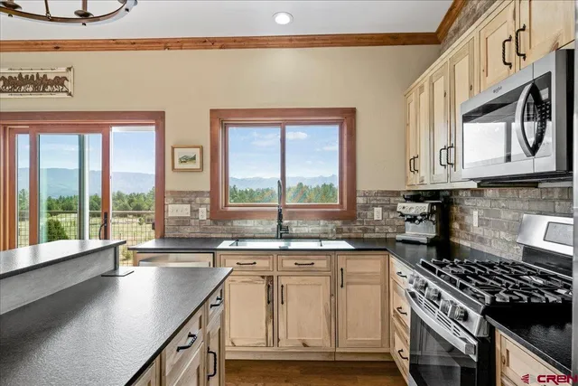 a kitchen with stainless steel appliances granite countertop a sink stove and cabinets
