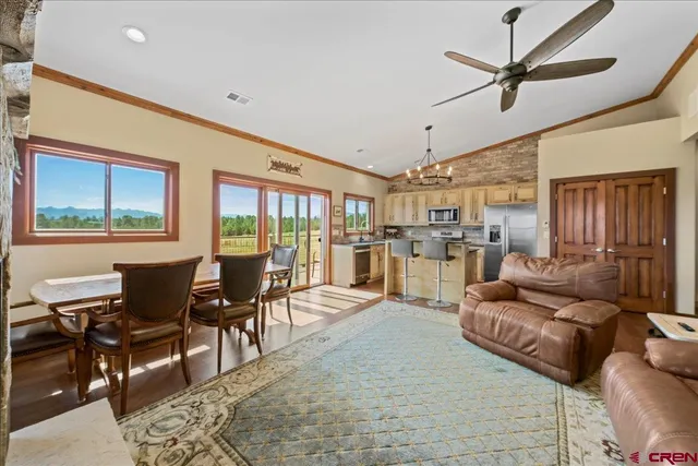 a living room with furniture kitchen view and a large window