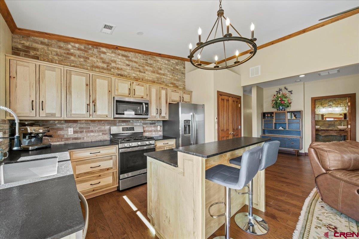 234 Thistle Drive Montrose, CO 81403 - Photo 4 of 39 a kitchen with stainless steel appliances granite countertop a stove and a refrigerator