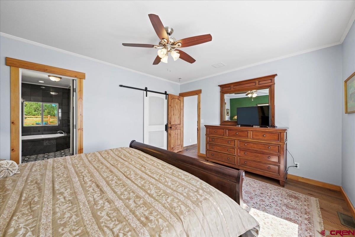 234 Thistle Drive Montrose, CO 81403 - Photo 10 of 39 a bedroom with a large bed and a chandelier