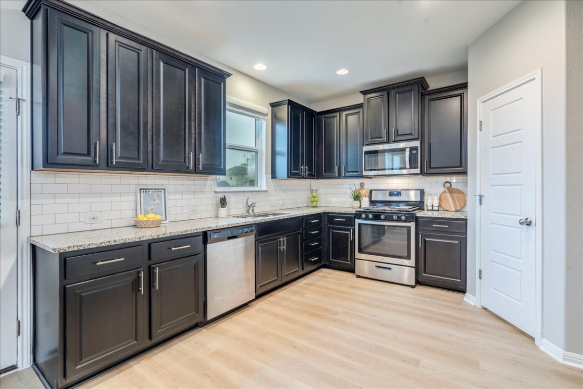 10317 Laurie Lane Austin, TX 78747 - Photo 1 of 35 a kitchen with kitchen island granite countertop stainless steel appliances and wooden cabinets