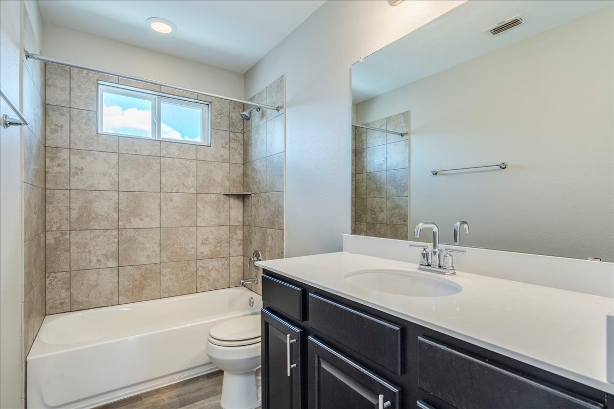 10317 Laurie Lane Austin, TX 78747 - Photo 19 of 35 Full bathroom featuring bathing tub / shower combination, vanity, and dark wood-style floors